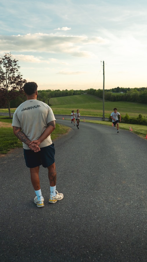 Coach watching sprint drills at sunset